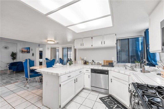37908 52nd St E, Palmdale, CA 93552 - kitchen featuring dishwasher, a peninsula, tile countertops, and white cabinetry