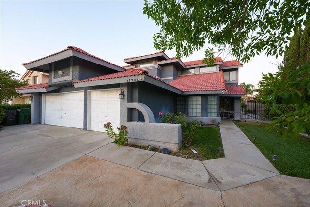 37908 52nd St E, Palmdale, CA 93552 - view of front of home with stucco siding, concrete driveway, a tiled roof, and a garage