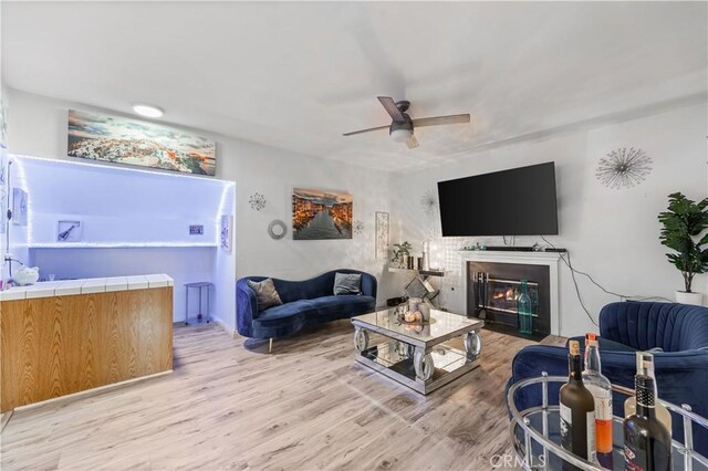 37908 52nd St E, Palmdale, CA 93552 - living room featuring ceiling fan, light wood finished floors, and a glass covered fireplace