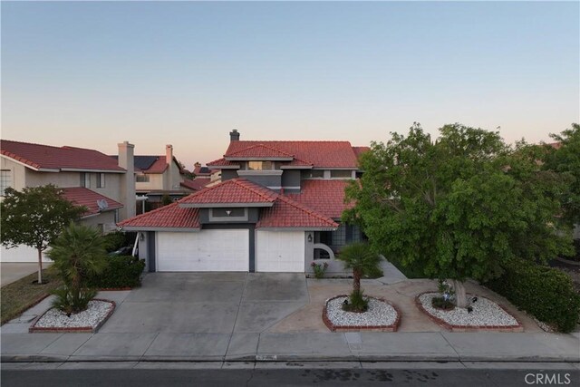 37908 52nd St E, Palmdale, CA 93552 - mediterranean / spanish home featuring a tiled roof, stucco siding, concrete driveway, an attached garage, and a chimney