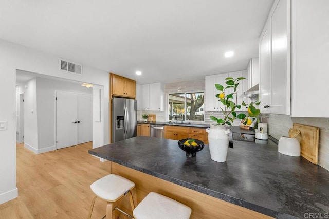 10437 Hermanos Rd, San Diego, CA 92124 - kitchen featuring stainless steel appliances, decorative backsplash, a peninsula, white cabinets, and recessed lighting