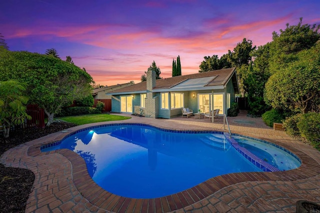 10437 Hermanos Rd, San Diego, CA 92124 - pool at dusk featuring a patio area, a fenced backyard, and a pool with connected hot tub