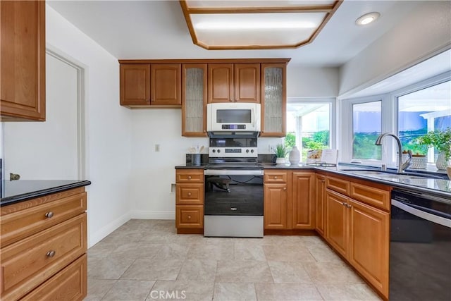 24482 Chrisanta Dr, Mission Viejo, CA 92691 - kitchen with electric range, dishwashing machine, white microwave, dark countertops, and brown cabinets