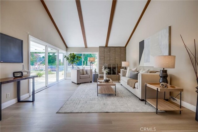 24482 Chrisanta Dr, Mission Viejo, CA 92691 - living area featuring beamed ceiling, wood finished floors, a fireplace, and high vaulted ceiling