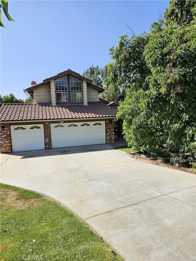 10771 Orchard View Ln, Riverside, CA 92503 - traditional-style home with a tile roof, driveway, brick siding, and an attached garage