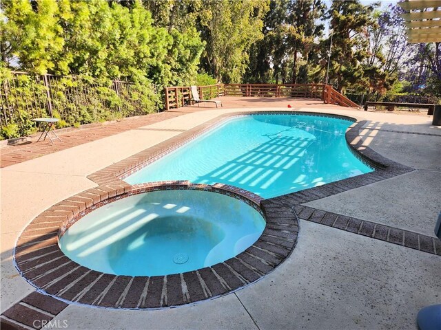 10771 Orchard View Ln, Riverside, CA 92503 - view of pool featuring a pool with connected hot tub, a patio area, and view of scattered trees