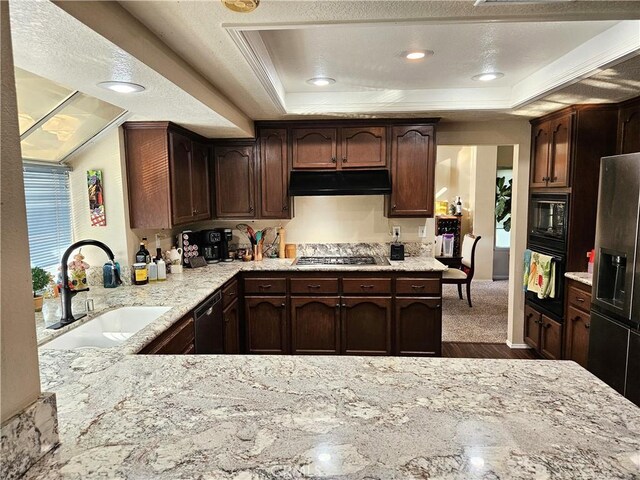 10771 Orchard View Ln, Riverside, CA 92503 - kitchen with under cabinet range hood, black appliances, a tray ceiling, dark wood-style flooring, and light stone counters