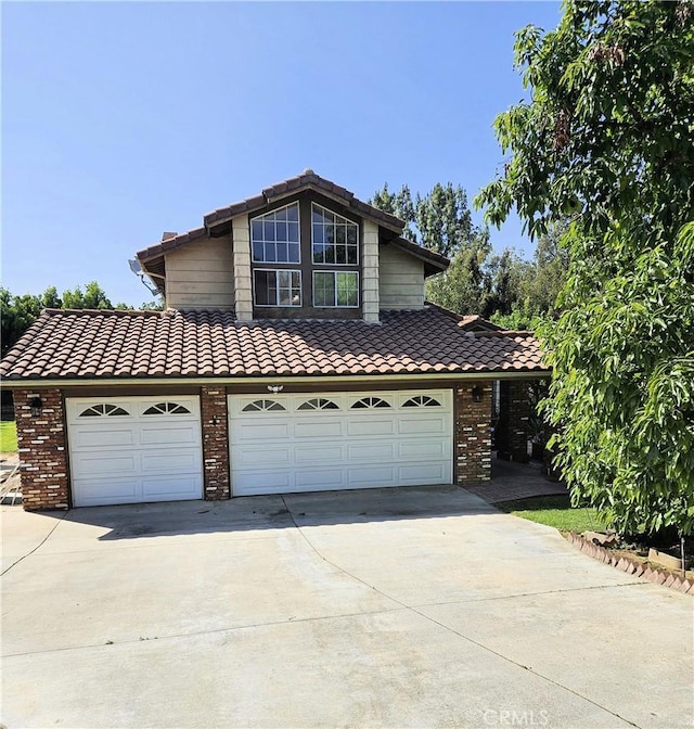10771 Orchard View Ln, Riverside, CA 92503 - traditional home with a tile roof, driveway, brick siding, and an attached garage