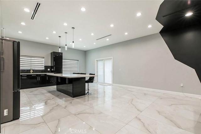 17800 Raymer St, Sherwood Forest, CA 91325 - kitchen featuring freestanding refrigerator, dark cabinets, a breakfast bar, a large island, and light marble finish floors