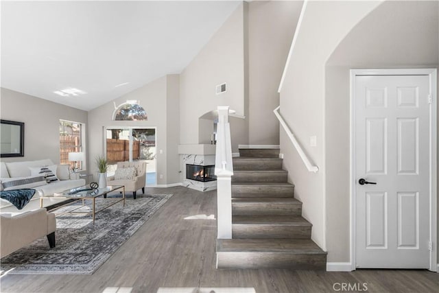 37921 Tackstem St, Palmdale, CA 93552 - living area featuring wood finished floors, a premium fireplace, stairs, arched walkways, and high vaulted ceiling
