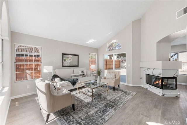 37921 Tackstem St, Palmdale, CA 93552 - living room with wood finished floors, high vaulted ceiling, a high end fireplace, and arched walkways