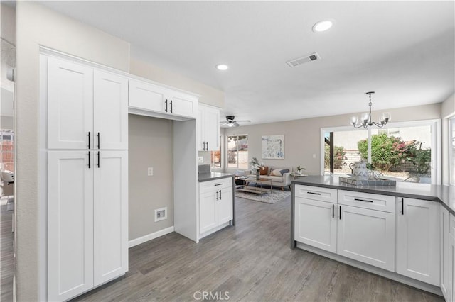 37921 Tackstem St, Palmdale, CA 93552 - kitchen featuring dark countertops, white cabinetry, wood finished floors, a chandelier, and ceiling fan