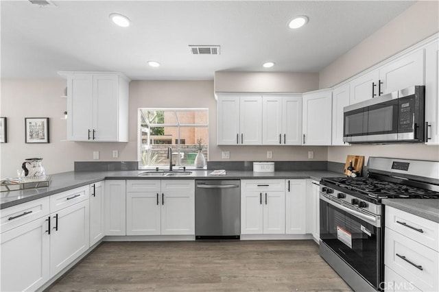 37921 Tackstem St, Palmdale, CA 93552 - kitchen with stainless steel appliances, white cabinetry, recessed lighting, light wood finished floors, and dark countertops