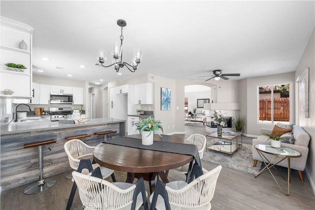 37921 Tackstem St, Palmdale, CA 93552 - dining room with a chandelier, light wood-style floors, arched walkways, a ceiling fan, and recessed lighting