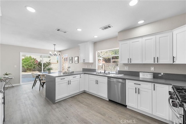 37921 Tackstem St, Palmdale, CA 93552 - kitchen featuring stainless steel appliances, a chandelier, white cabinets, light wood-style floors, and a peninsula