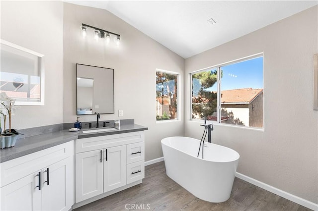 37921 Tackstem St, Palmdale, CA 93552 - full bath with lofted ceiling, a soaking tub, wood finished floors, and vanity