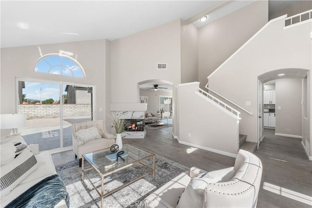 37921 Tackstem St, Palmdale, CA 93552 - living area with arched walkways, a ceiling fan, high vaulted ceiling, wood finished floors, and stairway