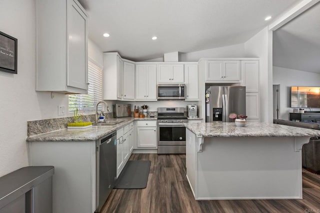 2605 Kauana Loa Dr, Escondido, CA 92029 - kitchen with appliances with stainless steel finishes, vaulted ceiling, dark wood-style flooring, white cabinetry, and light stone counters