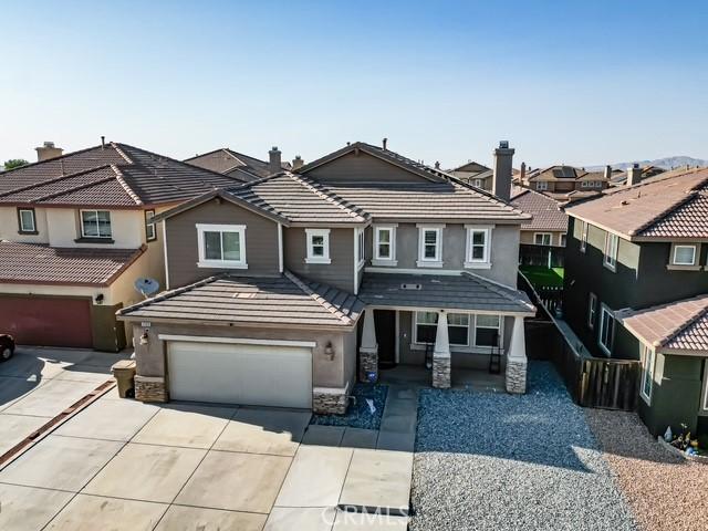 12920 La Costa Ct, Hesperia, CA 92344 - view of front of home with driveway, a garage, a residential view, stucco siding, and a porch
