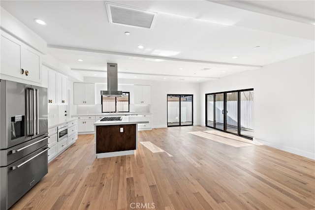 214 W Mariposa Unit B, San Clemente, CA 92672 - kitchen featuring appliances with stainless steel finishes, island exhaust hood, light wood-type flooring, white cabinets, and a kitchen island