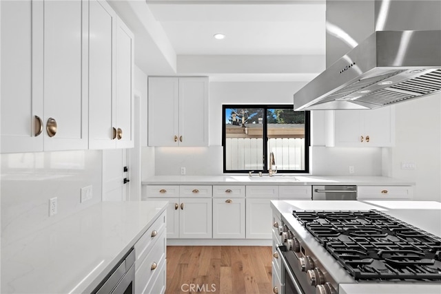 214 W Mariposa Unit B, San Clemente, CA 92672 - kitchen featuring wall chimney exhaust hood, light wood finished floors, stainless steel appliances, white cabinetry, and recessed lighting