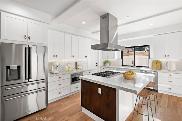 214 W Mariposa Unit B, San Clemente, CA 92672 - kitchen featuring appliances with stainless steel finishes, island range hood, a kitchen bar, light countertops, and recessed lighting
