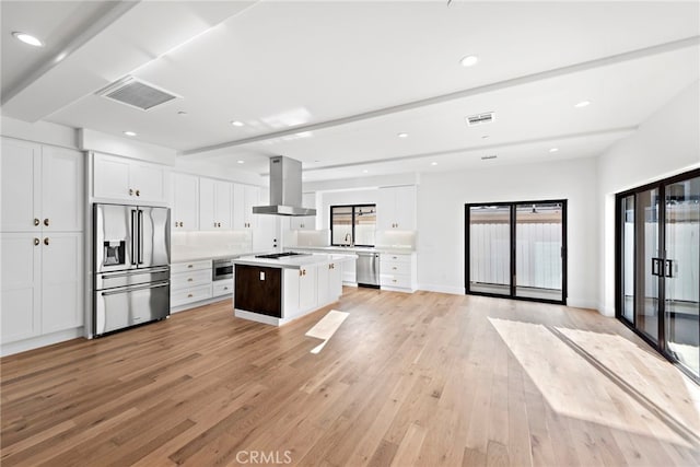 214 W Mariposa Unit B, San Clemente, CA 92672 - kitchen with wall chimney exhaust hood, appliances with stainless steel finishes, light wood-style flooring, white cabinetry, and light countertops