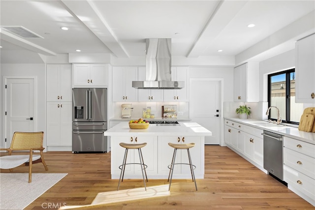 214 W Mariposa Unit B, San Clemente, CA 92672 - kitchen featuring appliances with stainless steel finishes, wall chimney exhaust hood, beamed ceiling, a center island, and a kitchen breakfast bar