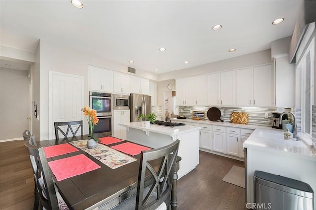 3 Heatherwood, Irvine, CA 92620 - kitchen featuring stainless steel appliances, tasteful backsplash, dark wood finished floors, white cabinets, and light countertops