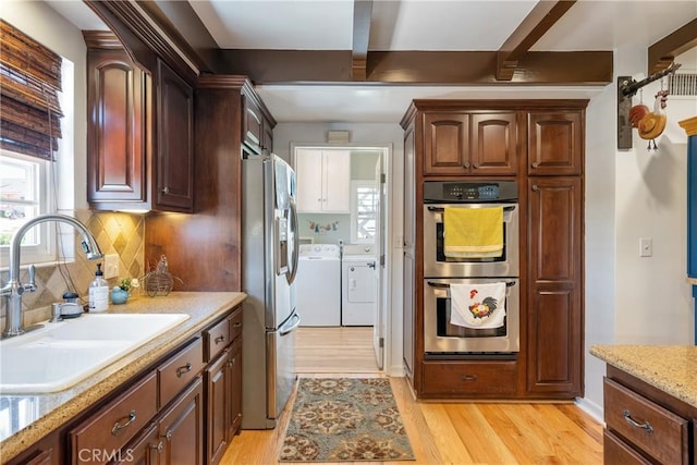 469 N Nearglen Ave, Covina, CA 91724 - kitchen featuring appliances with stainless steel finishes, washer and clothes dryer, light wood-type flooring, healthy amount of natural light, and beamed ceiling