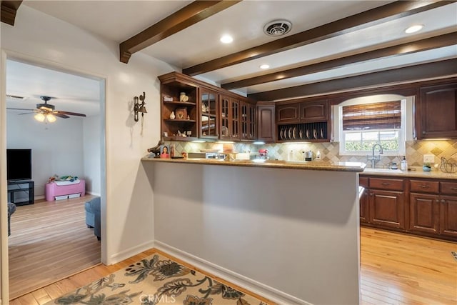 469 N Nearglen Ave, Covina, CA 91724 - kitchen with beam ceiling, backsplash, light wood-style flooring, glass insert cabinets, and a ceiling fan