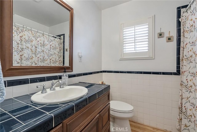 469 N Nearglen Ave, Covina, CA 91724 - bathroom featuring vanity, tile walls, wood finished floors, a wainscoted wall, and a shower with shower curtain