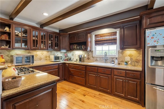 469 N Nearglen Ave, Covina, CA 91724 - kitchen featuring appliances with stainless steel finishes, beam ceiling, light wood finished floors, decorative backsplash, and light stone counters