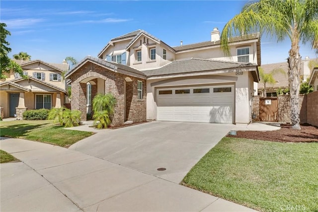 24934 Pine Creek Loop, Corona, CA 92883 - view of front of house featuring driveway, a chimney, stucco siding, and brick siding