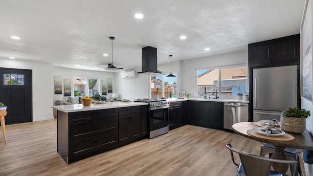 6117 Parkside Ave, San Diego, CA 92139 - kitchen featuring stainless steel appliances, island exhaust hood, a peninsula, light countertops, and dark cabinets