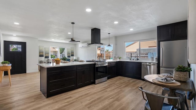6117 Parkside Ave, San Diego, CA 92139 - kitchen with stainless steel appliances, island exhaust hood, dark cabinets, a peninsula, and light countertops