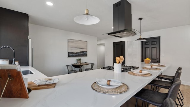 6117 Parkside Ave, San Diego, CA 92139 - kitchen featuring island exhaust hood, a kitchen breakfast bar, decorative light fixtures, and light countertops