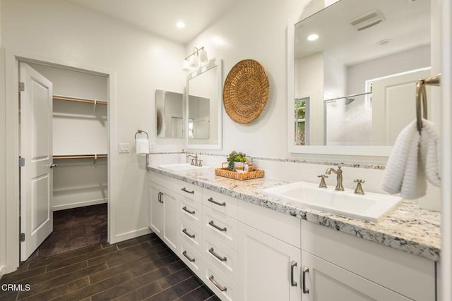 11570 Oakcrest Ave, Ojai, CA 93023 - bathroom with double vanity, wood finish floors, a shower with door, recessed lighting, and a walk in closet