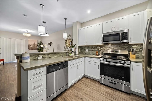24545 Town Center Dr Unit 5201, Valencia, CA 91355 - kitchen with appliances with stainless steel finishes, a peninsula, decorative backsplash, white cabinets, and recessed lighting