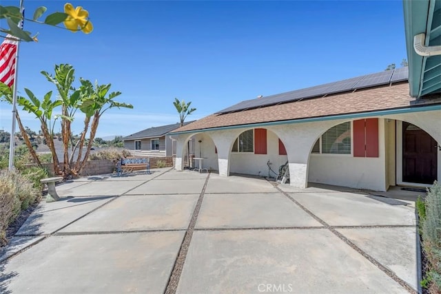 360 Carpio Dr, Diamond Bar, CA 91765 - view of front of home with stucco siding, roof mounted solar panels, a patio area, and roof with shingles