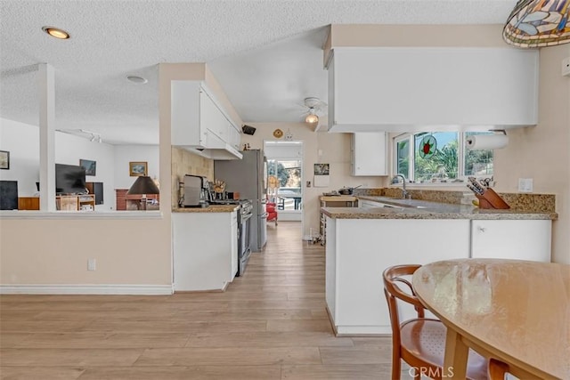 360 Carpio Dr, Diamond Bar, CA 91765 - kitchen featuring light wood finished floors, a textured ceiling, white cabinets, stainless steel range oven, and a peninsula