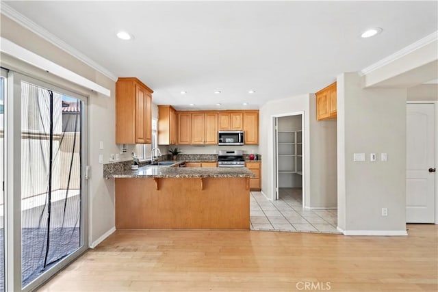 3919 W 242nd St Unit A, Torrance, CA 90505 - kitchen featuring appliances with stainless steel finishes, a peninsula, light wood-type flooring, recessed lighting, and crown molding