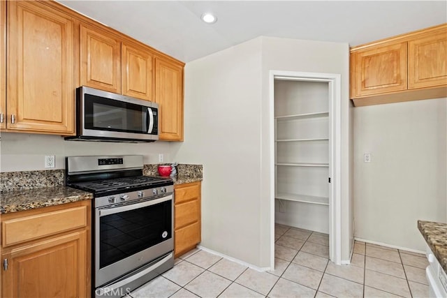 3919 W 242nd St Unit A, Torrance, CA 90505 - kitchen with appliances with stainless steel finishes, dark stone counters, light tile patterned floors, and recessed lighting