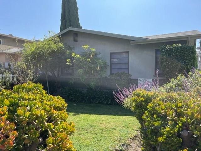 10856 Camarillo St, Toluca Lake, CA 91602 - view of side of home featuring stucco siding and a lawn