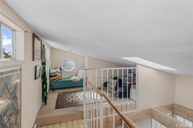 259 62nd, Newport Beach, CA 92663 - corridor with vaulted ceiling, healthy amount of natural light, a skylight, wood finished floors, and an upstairs landing