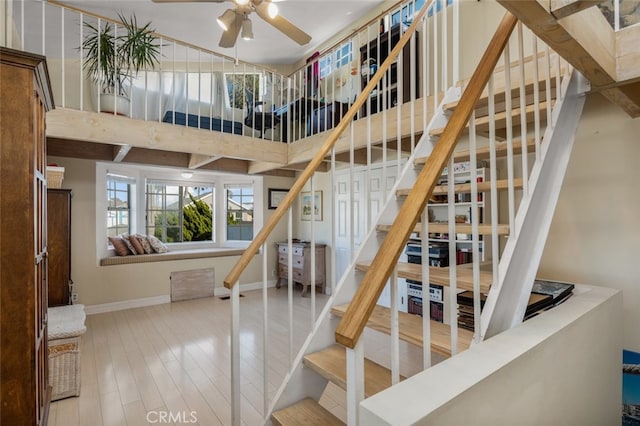 259 62nd, Newport Beach, CA 92663 - staircase featuring ceiling fan, a towering ceiling, and wood finished floors