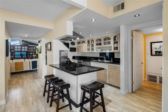 259 62nd, Newport Beach, CA 92663 - kitchen with light wood-style flooring, a kitchen bar, glass insert cabinets, dark countertops, and recessed lighting