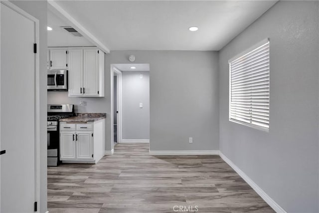 12178 Galaxy St, Victorville, CA 92392 - kitchen featuring stainless steel appliances, white cabinets, light wood-type flooring, recessed lighting, and stone countertops