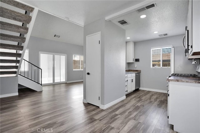 12178 Galaxy St, Victorville, CA 92392 - kitchen featuring white cabinets, dark wood-type flooring, stainless steel microwave, a textured ceiling, and open floor plan