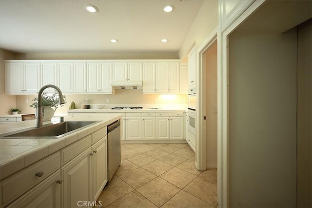 25217 Pacific Crest St, Corona, CA 92883 - kitchen with under cabinet range hood, gas cooktop, stainless steel dishwasher, tile countertops, and light tile patterned floors